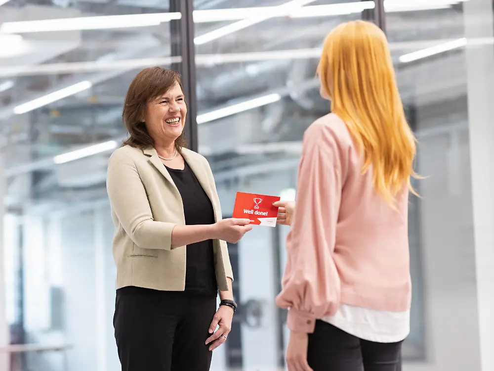 Two Henkel employees chatting in the hallway